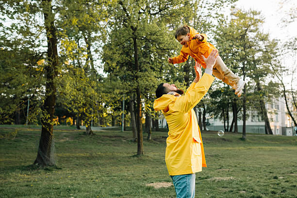 istock Father lifting happy child in park at sunset 2227623938