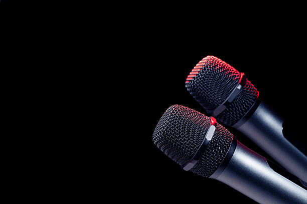istock Close-up of microphone in studio or concert performance on stage, on black background. 2227628157