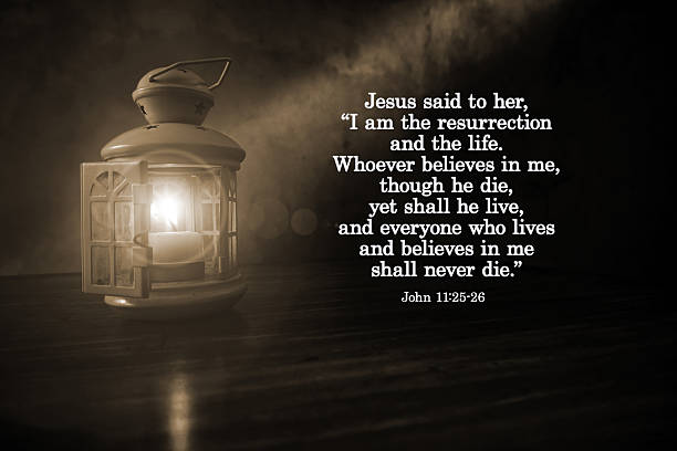 Bible verse quote - Jesus said to her, I am the resurrection and the life. The one who believes in me will live, even though they die. John 11:25-26 With lantern light in the night in sepia background