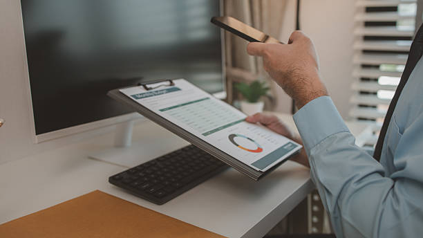 istock an entrepreneur is working diligently in an office, a businessman is using a smartphone to take a photo of a document, the manager is reviewing a document, marketing, company, accountant 2227634432