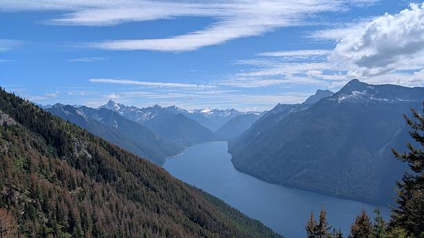 istock Beautiful calm lake surrounded by mountain range under majestic clouds 2227639617