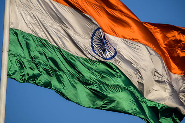 istock India flag flying high at Connaught Place with pride with plain white background, India flag fluttering, Indian Flag on Independence Day and Republic Day of India, tilt up shot, Har Ghar Tiranga 2227639876