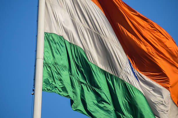 istock India flag flying high at Connaught Place with pride with plain white background, India flag fluttering, Indian Flag on Independence Day and Republic Day of India, tilt up shot, Har Ghar Tiranga 2227639877