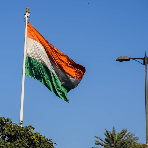 istock India flag flying high at Connaught Place with pride with plain white background, India flag fluttering, Indian Flag on Independence Day and Republic Day of India, tilt up shot, Har Ghar Tiranga 2227639878