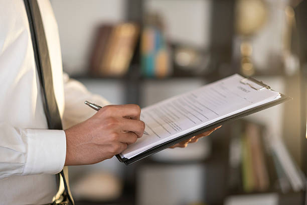 istock Businessman signing a contract on clipboard in office 2227640698
