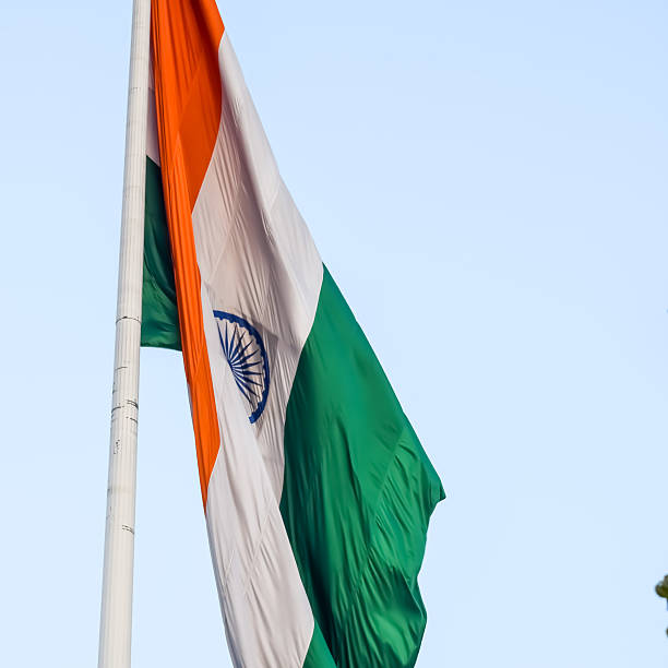 istock India flag flying high at Connaught Place with pride with plain white background, India flag fluttering, Indian Flag on Independence Day and Republic Day of India, tilt up shot, Har Ghar Tiranga 2227640755