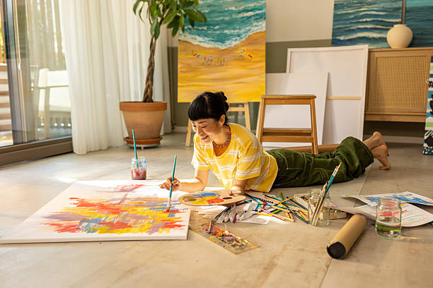 istock Woman painting at home in bright studio space 2227642993