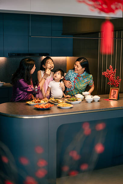 Chinese Asian multi generation family members have fun while preparing for reunion dinner