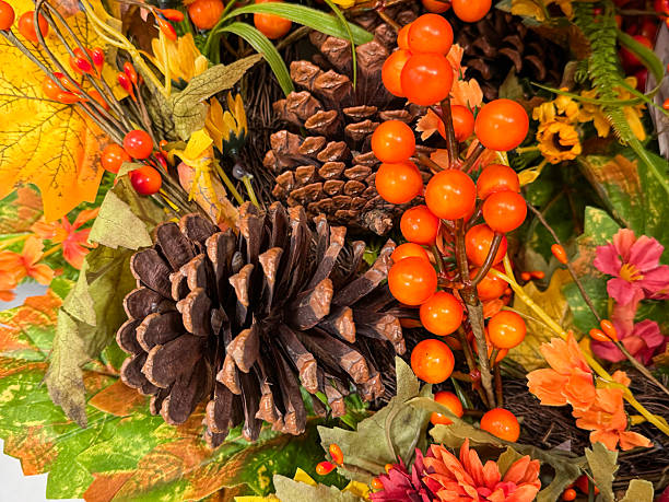istock Full frame image of autumn decoration display wreath, green eucalyptus and artificial foliage, autumnal coloured maple leaves, dried pinecones, fake berries, yellow and orange flowers, autumnal background wallpaper, focus on foreground 2227644089
