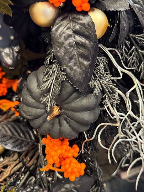 istock Full frame image of Halloween party decoration display wreath, black and silver grey artificial foliage, fake orange berries, black plastic pumpkins, silver artificial twigs, gold baubles, Halloween background wallpaper, focus on foreground 2227644112