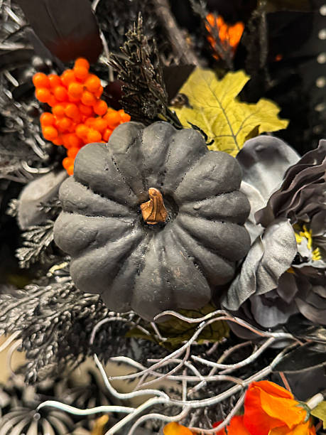 istock Full frame image of Halloween party decoration display wreath, black and silver grey artificial foliage, fake orange berries, black plastic pumpkins, silver artificial twigs, orange flower heads, Halloween background wallpaper, focus on foreground 2227644120
