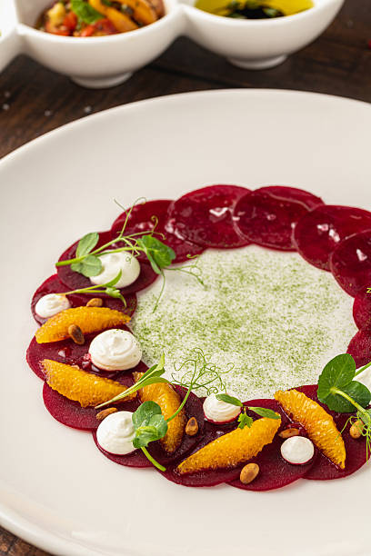 istock Beet carpaccio with orange slices, fresh greens and cream dots 2227647498