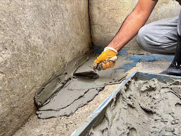 istock Manual Laborer Applying Wet Cement with a Trowel on a Foundation 2227648281