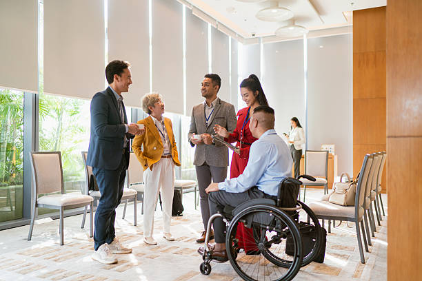 istock Businessman with disability networks with peers during a conference break 2227649776