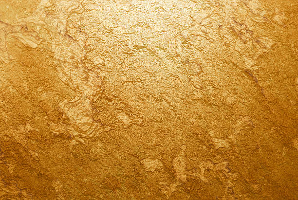 istock Golden textured surface with shimmering metallic shine and natural stone pattern. Abstract golden background ideal for luxury design, decoration, or product packaging. Gold stone raw 2227650107