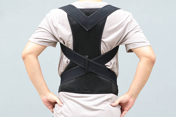 istock Young asian man wearing a back support belt, Lumbar brace for back trauma or Herniated Disc To relieve back pain. background 2227650308