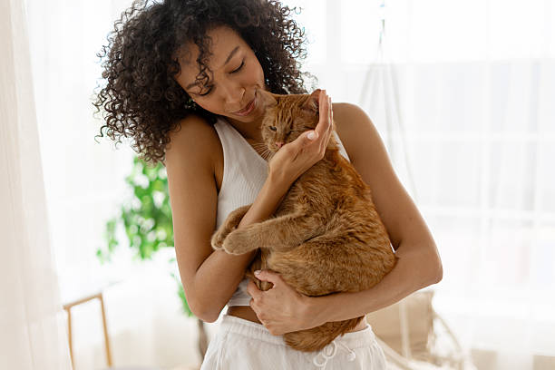 istock Young woman cuddling her ginger cat at home 2227651312