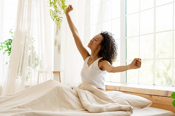 istock Young Woman Stretching in Bed After Waking Up 2227651369