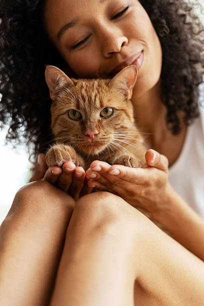 istock Young woman cuddling her ginger cat at home 2227652425