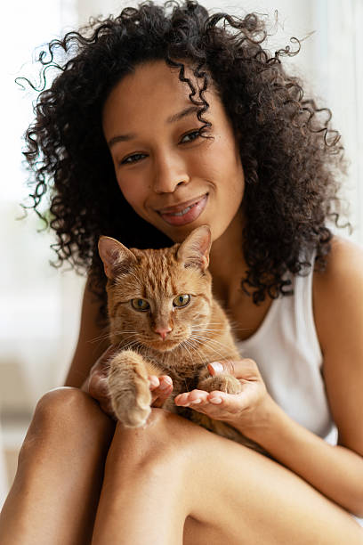 istock Young Woman Holding her Ginger Cat on her Lap Smiling 2227652546