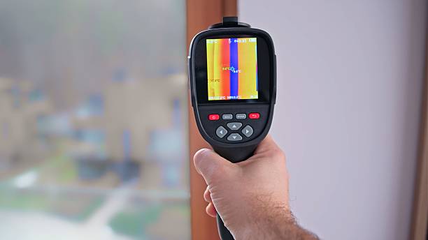 istock Caucasian Contractor Engineer Performing Building Inspection for Cold Bridge Thermal Bypass in Window Frame using Thermal Vision Camera 2227652557