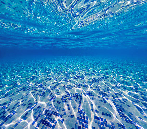 istock Swimming pool underwater, blue tiles with light caustic reflections. 2227655224