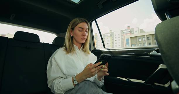 istock A woman uses a mobile phone in a car 2227656025