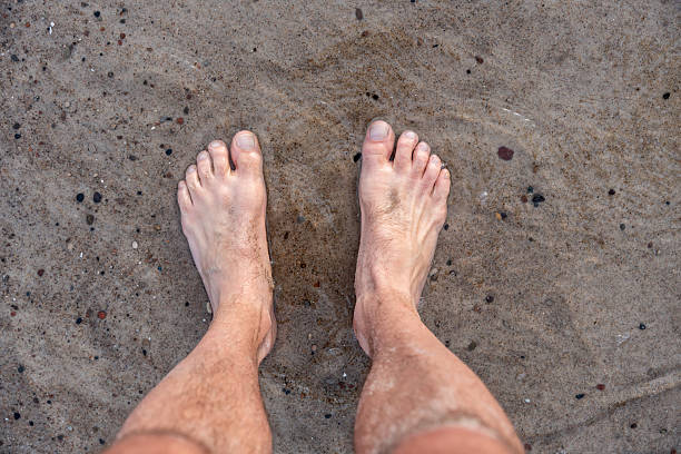 istock Bare Feet Standing On Wet Sand By The Shore 2227656383