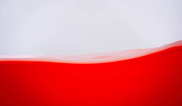 istock Close-up abstract image of smooth red liquid waves over soft white background, highlighting elegant motion and minimal composition. Perfect for design or wellness visuals. 2227656833