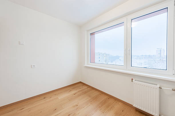 istock Bright Empty Room With Wooden Flooring and Large Window Overlooking Urban Scenery 2227656975