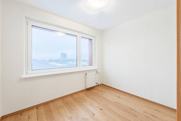 istock Bright Empty Room With Wooden Flooring and Large Window Overlooking Urban Scenery 2227657280