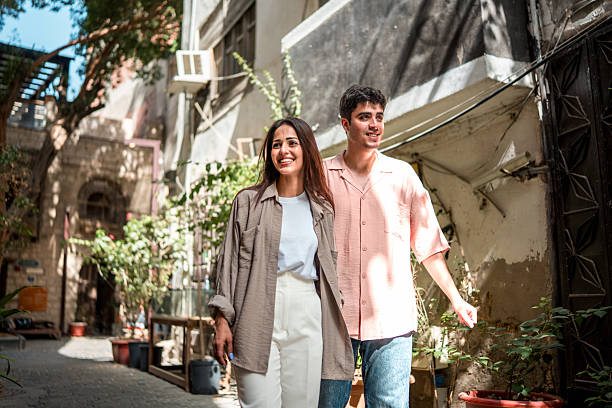 Young Couple Strolling Through Al-Balad in Bright Sunlight with Joyful Expressions