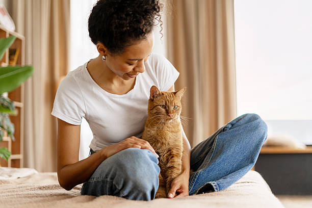 istock Young Woman Relaxing on Bed with Ginger Cat 2227658062