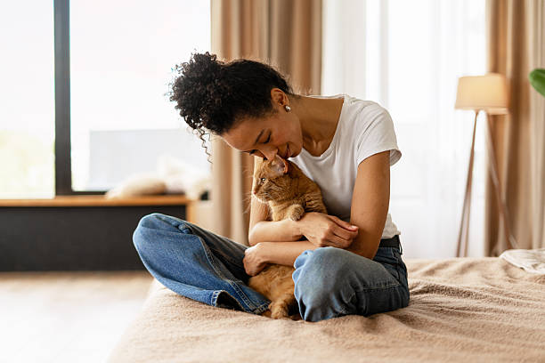 Young Woman Showing Affection to Her Ginger Cat on Bed