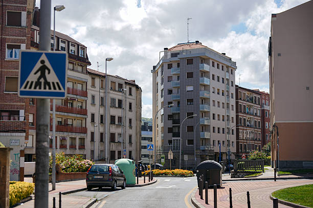 Urban street with residential buildings, crosswalk signs and cars in Barakaldo, Spain, on July 29, 2025. Everyday life in the Basque Country. Editorial use only.