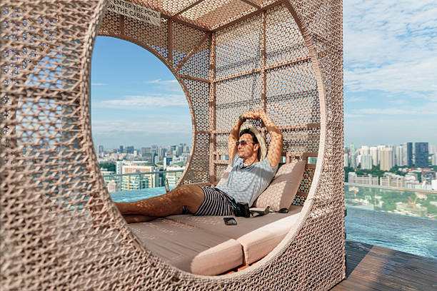 istock Asian man staying connected online while relaxing by the poolside 2227660834
