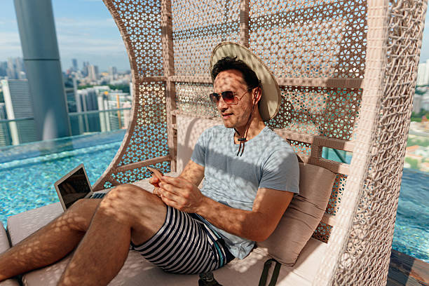 istock Asian man staying connected online while relaxing by the poolside 2227660858