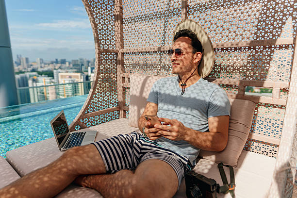 istock Asian man staying connected online while relaxing by the poolside 2227660952