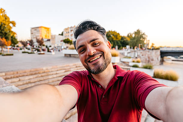istock Mid-Adult Man Taking Selfies While Sitting On The Quayside 2227662115