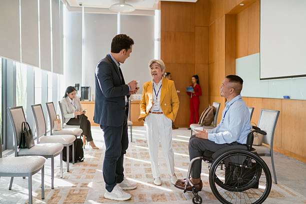 istock Businessman with disability networks with peers during a conference break 2227664854