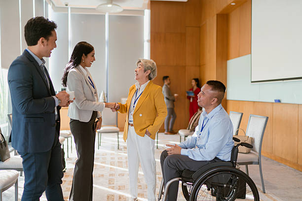 istock Businessman with disability networks with peers during a conference break 2227665034