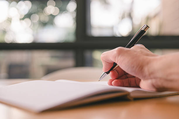 istock Hand Writing with Pen on Notebook with Soft Bokeh Background 2227666068