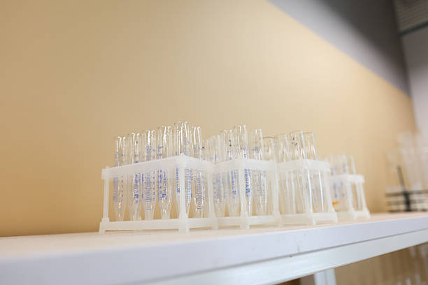 Group of children in lab coats and gloves performing chemistry experiments using glassware, hot plates, scales, and liquid reagents in a modern laboratory setting.