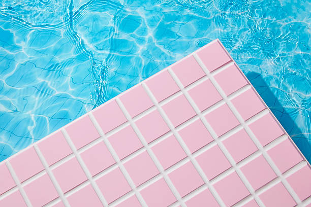 Clear turquoise water meets soft pink mosaic tiles, forming a sleek poolside layout with architectural appeal. A serene space perfect for placing product designs or natural beauty mockups.