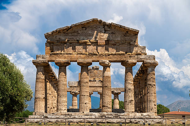 Capaccio Paestum - Kampanien - Italien - 07-06-2025: Front-facing view of a well-preserved Doric temple ruin with stone columns under a blue sky, located at the archaeological site of Paestum.