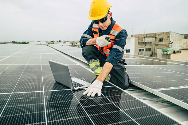 istock Technician working on solar panels on a rooftop in an urban setting during overcast weather 2227677509