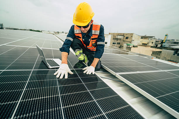 istock Engineer inspects solar panels on a rooftop while using a laptop to monitor systems in an urban environment 2227677510