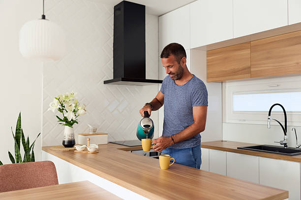 istock Man Preparing Coffee in Modern Minimalistic Kitchen with Stylish Wood Decor 2227679813