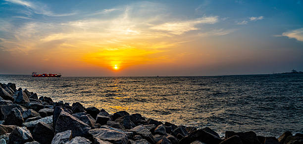 A breathtaking panoramic view of the sunset over the Arabian Sea at Fort Kochi, Kerala. This serene coastal scene captures warm golden hues, fishing boats, and tranquil waters, reflecting the charm of Kerala's historic port town. Ideal for travel visuals, documentaries, and landscape collections.