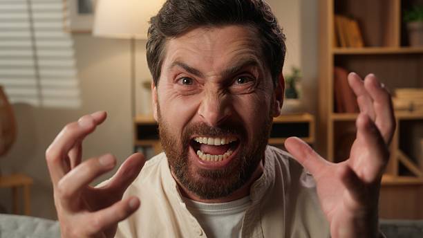 Crazy male man homeowner stressful on sofa problem crisis negative emotions angry annoyed scream shout Caucasian guy businessman yelling screaming at camera mad furious expression anger conflict home. High quality 4k footage